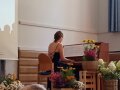 Frau sitzt am Klavier