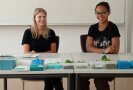 2 Personen sitzen an einem Tisch