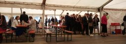 Personen sitzen und stehen in einem Festzelt