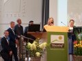Mehrere Personen stehen um Rednerpult