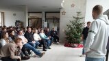 Person steht vor Personen auf Stühlen in einem Ram