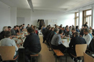 Mehrere Eltern an Tischen im Schulgebäude Triesdorf
